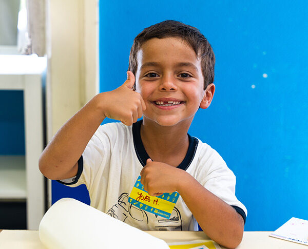 Criança a celebrar a sua invenção numa aula The Inventors