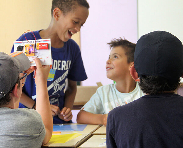 Grupo de crianças a rir e a mostrar o projeto que construíram